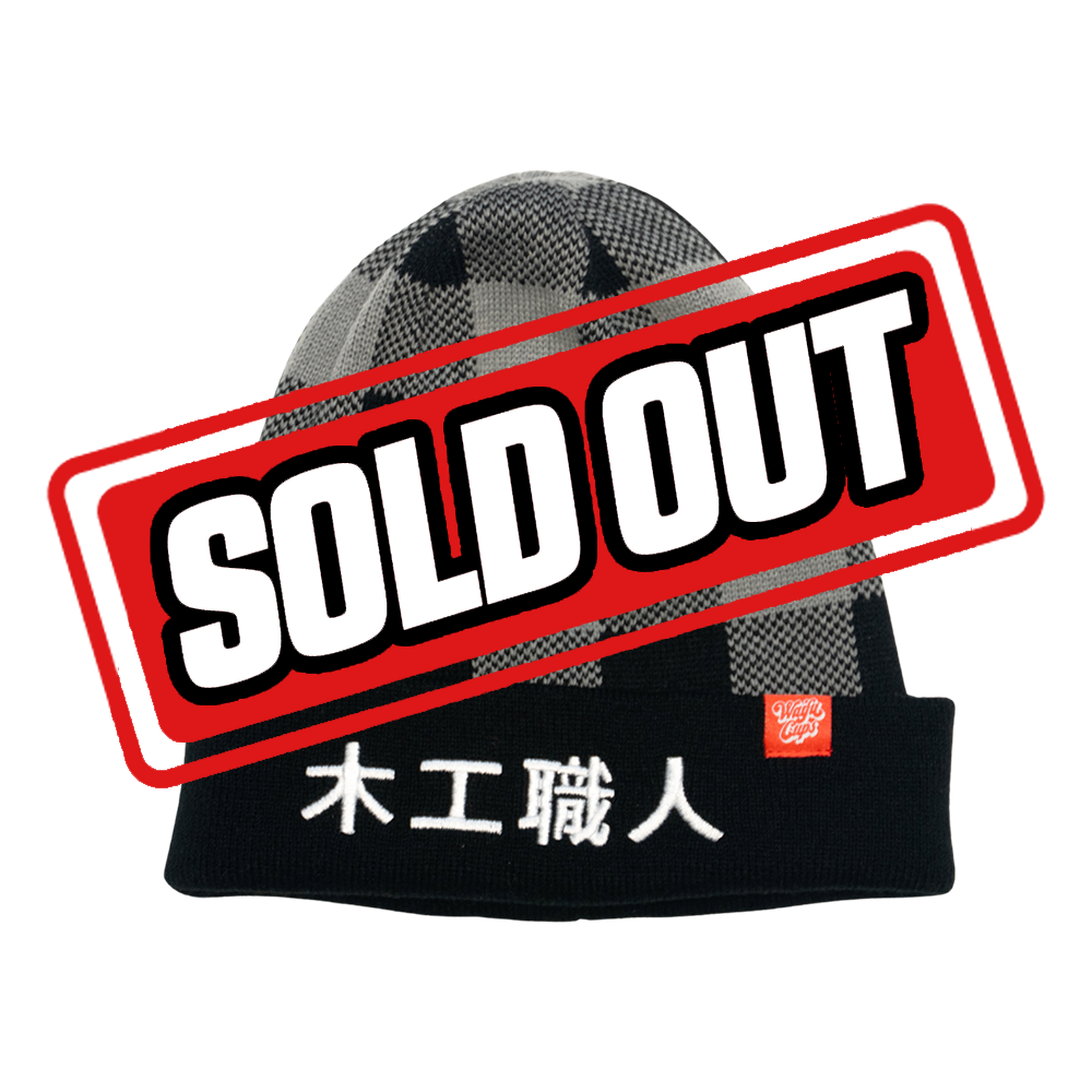 Black and gray checkered beanie with a black cuff featuring white Japanese characters and a small red tag.