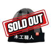 Black and gray checkered beanie with a black cuff featuring white Japanese characters and a small red tag.